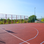 Zdjęcie przedstawia boisko o nawierzchni poliuretanowej do gry w piłkę nożną, piłkę ręczną, koszykówkę i siatkówkę