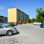 Parking dla mieszkańców ulic Zagórnej i Jarzębinowej z zaparkowanymi samochodami, w tle widoczny sklep Biedronka