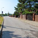 Asfaltowa ulica z obustronnymi chodnikami z kostki brukowej.