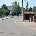 Asfaltowa ulica z obustronnymi chodnikami z kostki brukowej.
