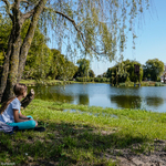 Staw przy ulicy Mickiewicza. Przy stawie pod wierzbą siedzi dziewczynka.