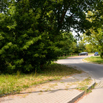 Na parkingu z kostki brukowej przy ulicy Letniej stoją dwa samochody.