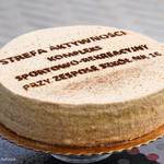 Duże zbliżenie na tort z napisem: Strefa Aktywności – kompleks sportowo-rekreacyjny przy Zespole Szkół nr 16.