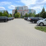 Parking z kostki polbruk. po prawej i lewej stronie ustawione samochody.