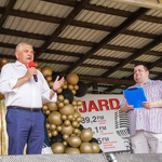 Prezydent przemawia do mikrofonu, obok stoi prowadzący. W tle balony i dach sceny.