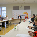 Przestronne jasne pomieszczenie. Kilkanaście osób siedzi przy stołach ostawionych w duży okrąg.