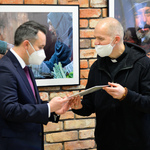 Autor wystawy wręcza fotografię Zastępcy Prezydenta.