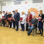 Jasne pomieszczenie. Prezydent Miasta oraz kilkanaście innych osób z teczkami w dłoniach pozuje do zdjęcia stojąc w rzędzie.