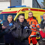 Zastępca Prezydenta Białegostoku mówi do mikrofonów skierowanych w jego stronę. Obok stoi kilku mężczyzn.