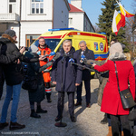 Prezydent Białegostoku wraz z kilkoma innymi osobami stoją na tle karetki. Otaczają ich dziennikarze trzymający w dłoniach mikrofony. 