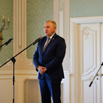 Wnętrze auli. Prezydent Białegostoku przemawia ze sceny do mikrofonu.