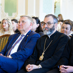 Wnętrze auli. Uczestnicy gali siedzą na krzesłach. W pierwszym rzędzie prezydent Białegostoku i przedstawiciele duchowieństwa. 