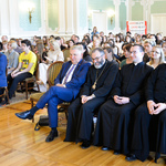 Wnętrze auli. Uczestnicy gali siedzą na krzesłach. W pierwszym rzędzie prezydent Białegostoku i przedstawiciele duchowieństwa. 
