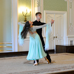 Wnętrze auli. Młoda kobieta i mężczyzna tańczą na scenie taniec klasyczny.