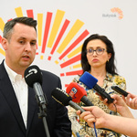 Zastępca prezydenta miasta mówi do kilku mikrofonów. Obok niego stoi Dyrektorka Centrum Aktywności Społecznej.