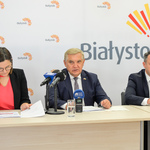 Prezydent mówi do mikrofonów ustawionych na stole. 