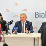 Prezydent mówi do mikrofonów ustawionych na stole. 