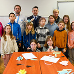 Zastępca prezydenta pozuje do zdjęcia z dziećmi uczestniczącymi w warsztatach, organizatorami i prowadzącymi. 
