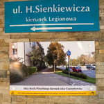 Tablica ze zdjęciem zamontowana na ceglastej ścianie przejścia podziemnego