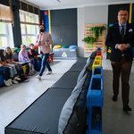 Kolorowy korytarz szkolny z siedziskami zrobionymi z palet.