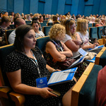 Sala projekcyjna Kina Forum zapełniona uczestnikami konferencji, którzy siedzą na fotelach kinowych.