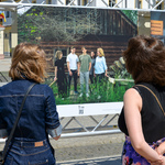 Trzy zwrócone tyłem do obiektywu kobiety stoją przed jedną z plansz wystawowych.