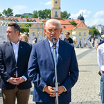 Otwarcie wystawy. Prezydent Miasta mówi do mikrofonu. Obok, po jednej stronie stoi jego zastępca, po drugiej autor fotografii. 