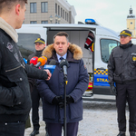 Zastępca prezydenta Białegostoku mówi do mikrofonów trzymanych przez dziennikarzy. Obok stoją inni uczestnicy konferencji prasowej.