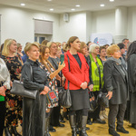 Uczestnicy spotkania zgromadzeni w przestronnej sali. 