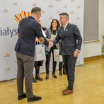 Zastępca prezydenta wręcza podziękowania członkowi ustępującej Rady.
