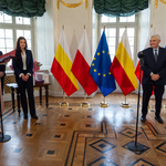 Barokowe wnętrze Pałacyku Gościnnego. W centralnej części flagi miasta, Polski i Uni Europejskiej. Po prawej prezydent Białegostoku, po lewej prowadząca spotkanie i pracownice Urzędu Miejskiego.