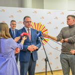 Konferencja prasowa. Przedstawiciel Polskiego Radia Białystok odpowiada na pytania stojących obok dziennikarzy.
